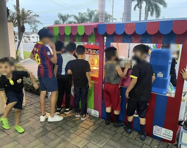 Dos puestos de Chewie Eventos, palomitas y granizados, rodeados de niños en una fiesta en Villa Club